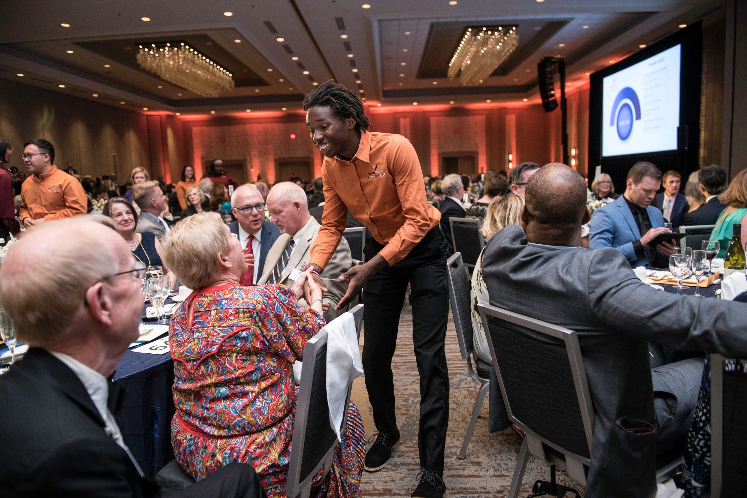 VocalEssence Singers Of This Age member shaking hand of a Gala attendee