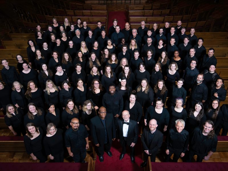 VocalEssence Ensemble Singers wearing black pose for a photo. Photo Credit: Bruce Silcox