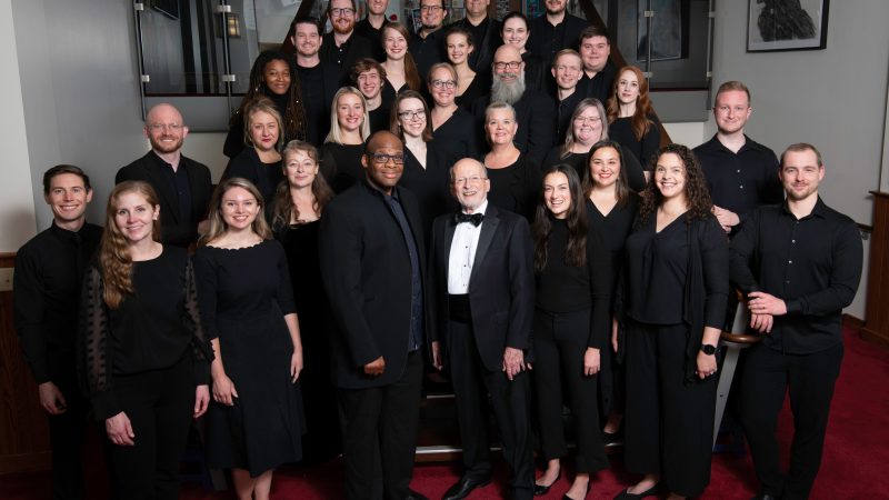 VocalEssence Ensemble Singers wearing black pose for a photo. Photo Credit: Bruce Silcox