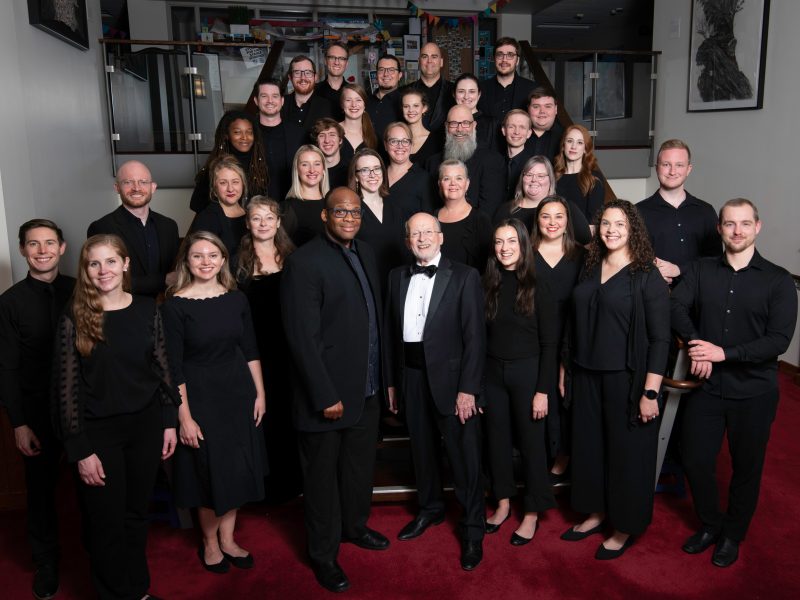 VocalEssence Ensemble Singers wearing black pose for a photo. Photo Credit: Bruce Silcox