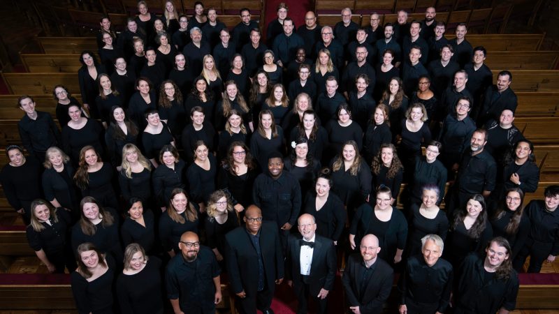 VocalEssence Chorus members wearing black pose for a photo. Photo Credit: Bruce Silcox