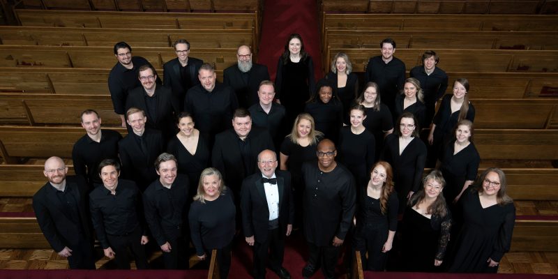 VocalEssence Ensemble Singers wearing black pose for a photo. Photo Credit: Bruce Silcox