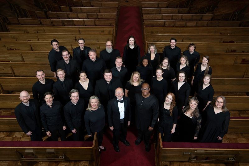 VocalEssence Ensemble Singers wearing black pose for a photo. Photo Credit: Bruce Silcox